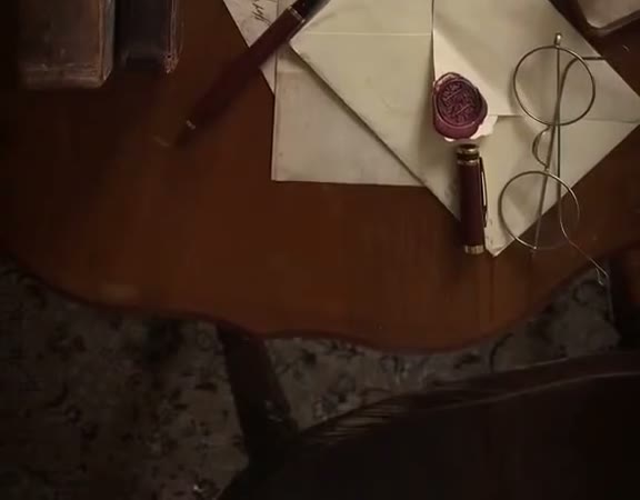 Letra të vjetra, dyll vulosjeje dhe syze mbi tavolinë druri